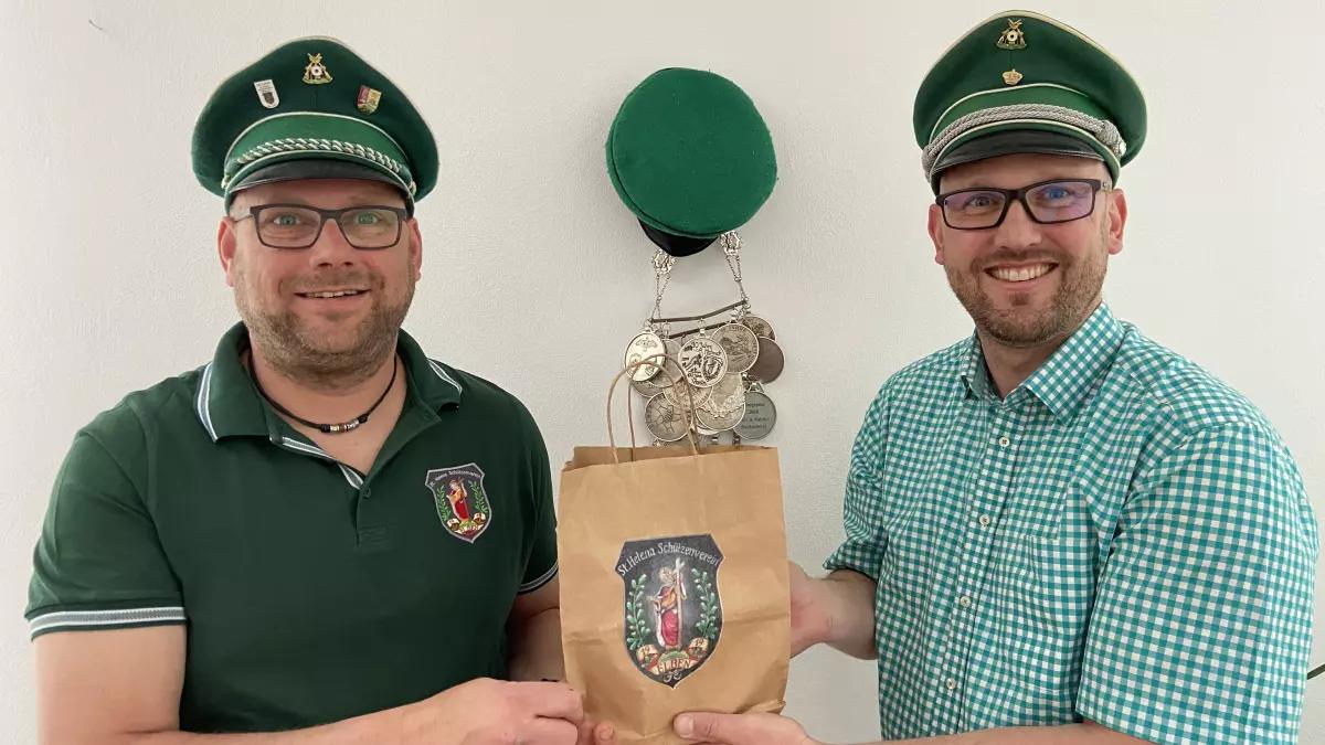 König Ralf Butzkamm (links) und Vorsitzender Stefan Clemens präsentieren eine der Schützenfesttüten.