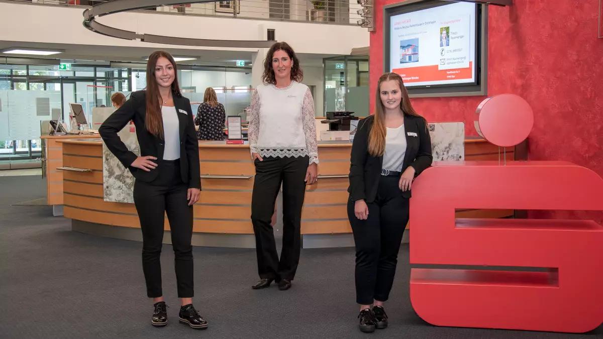 Ausbildungsleiterin Monika Schulte-Brinker (Mitte) begleitet die beiden neuen Sparkassen-Auszubildenden Emely Lips (links) und Ellen Sondermann (rechts) an ihrem ersten Arbeitstag beim Rundgang in der Hauptstelle in Olpe.