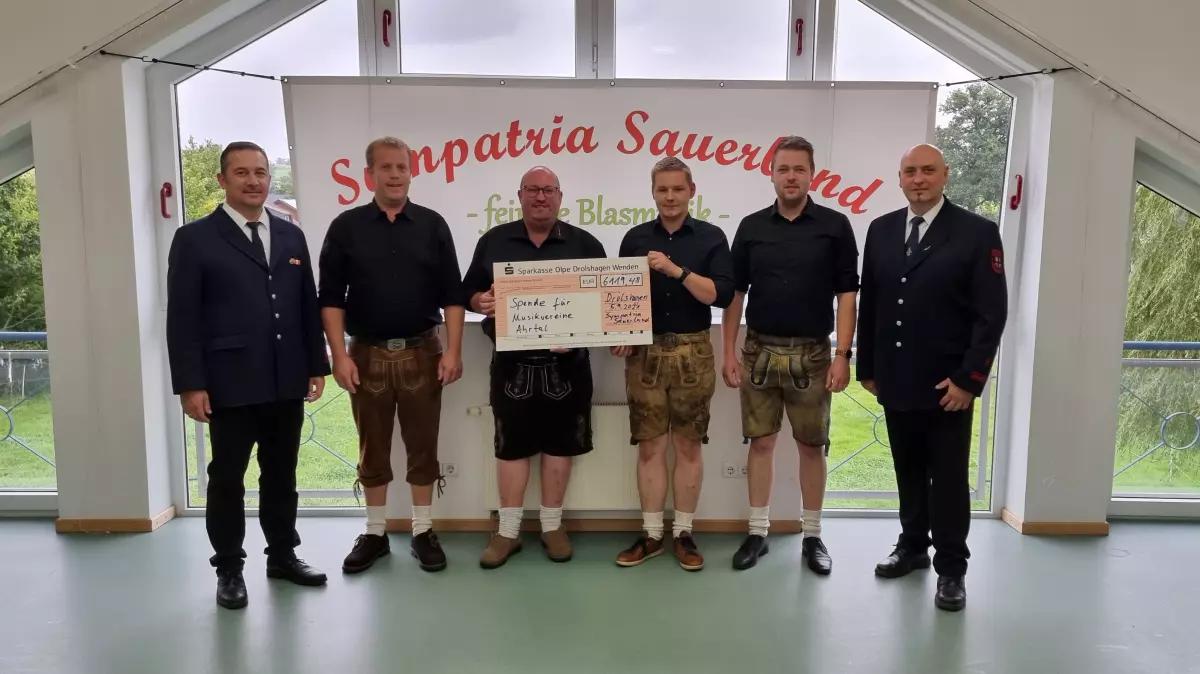 (von links): Stefan Schneider (1.Vorsitzender Musikzug Iseringhausen), Jan Schröter (Dirigent und musikalischer Leiter Sympatria Sauerland und Musikzug Drolshagen, Thomas Hermann (Organisation Sympatria Sauerland), Benedikt Reuber (Organisation Sympatria Sauerland), Pascal Hesse (Kassierer Sympatria Sauerland), Dirk Schulte (2. Vorsitzender Musikzug Drolshagen).