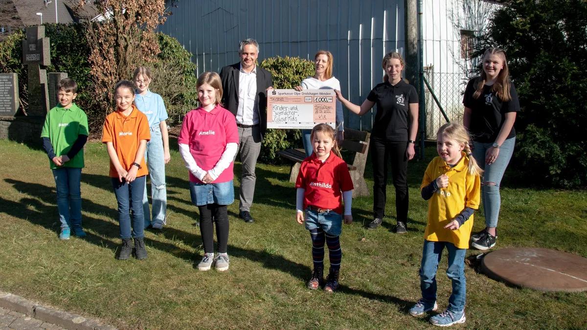 Matthias Würde, Leiter Privatkunden Drolshagen (hinten links), überreichte einen symbolischen Scheck an die Chorleiterin Silvia Mohaupt (hinten, 2. v. l.) .