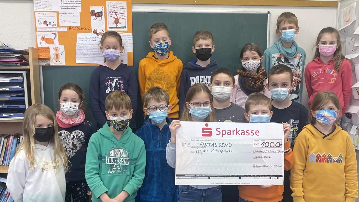 Die dritte Klasse der Grundschule Schönholthausen nimmt den symbolischen Scheck entgegen.