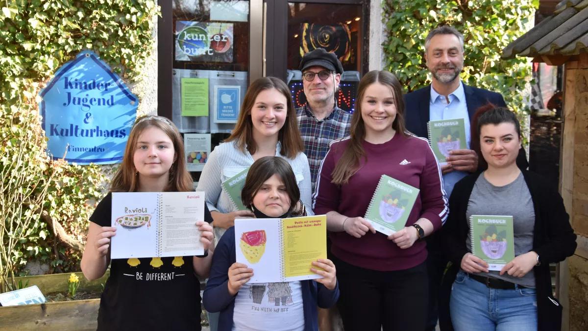 Emily Berendt, Geraldine Ernst, Natalie Dicke, Patricia Camen, Carmela Giamblanco (v.v.l), Michael Hunold (Einrichtungsleiter) und Michael Becker (Repräsentant der Stiftung its for kids) freuen sich über zahlreiche Käufer des Kochbuchs.