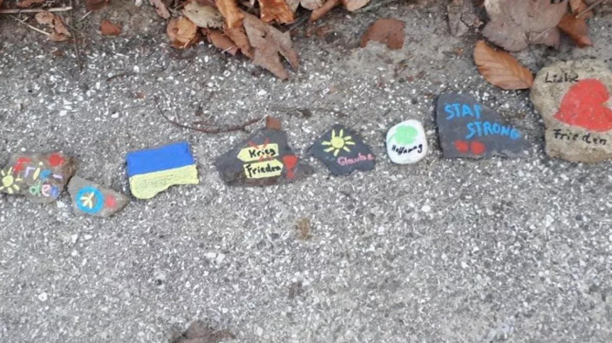 Die Kinder haben Steine als Zeichen für Frieden bemalt.
