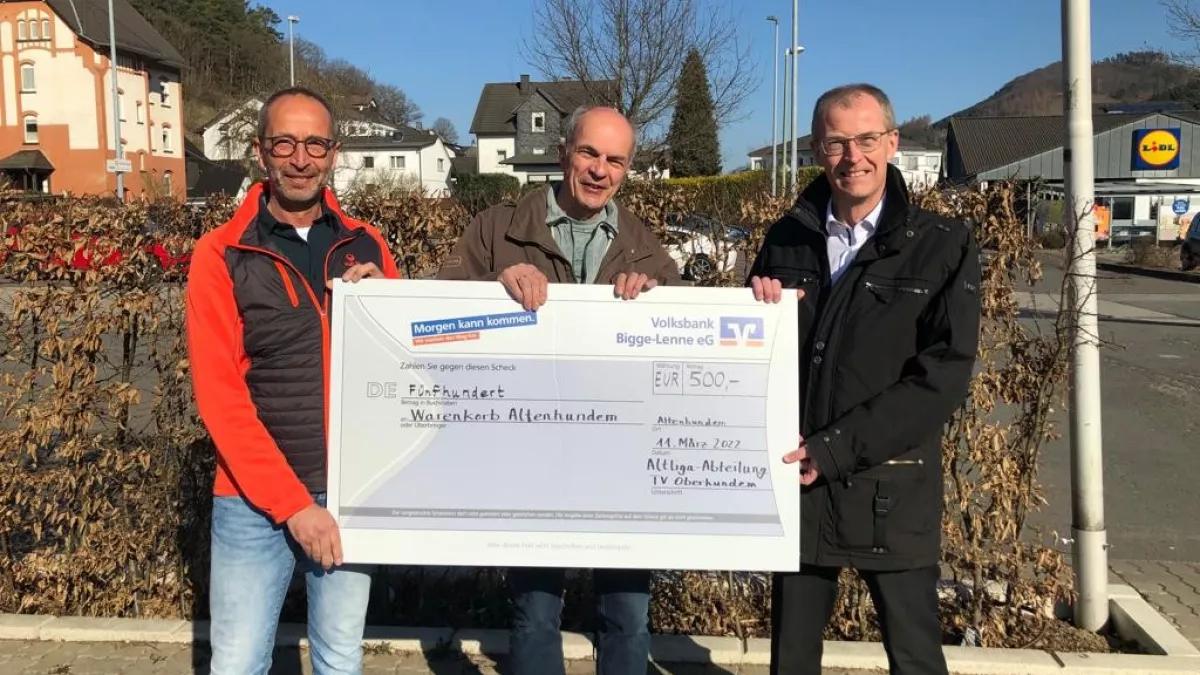 Klaus Hochstein (links) und Thomas Hähner (rechts), beide Altliga TVO, bei der Scheckübergabe an Jochen Dolle (Mitte) vom Warenkorb.