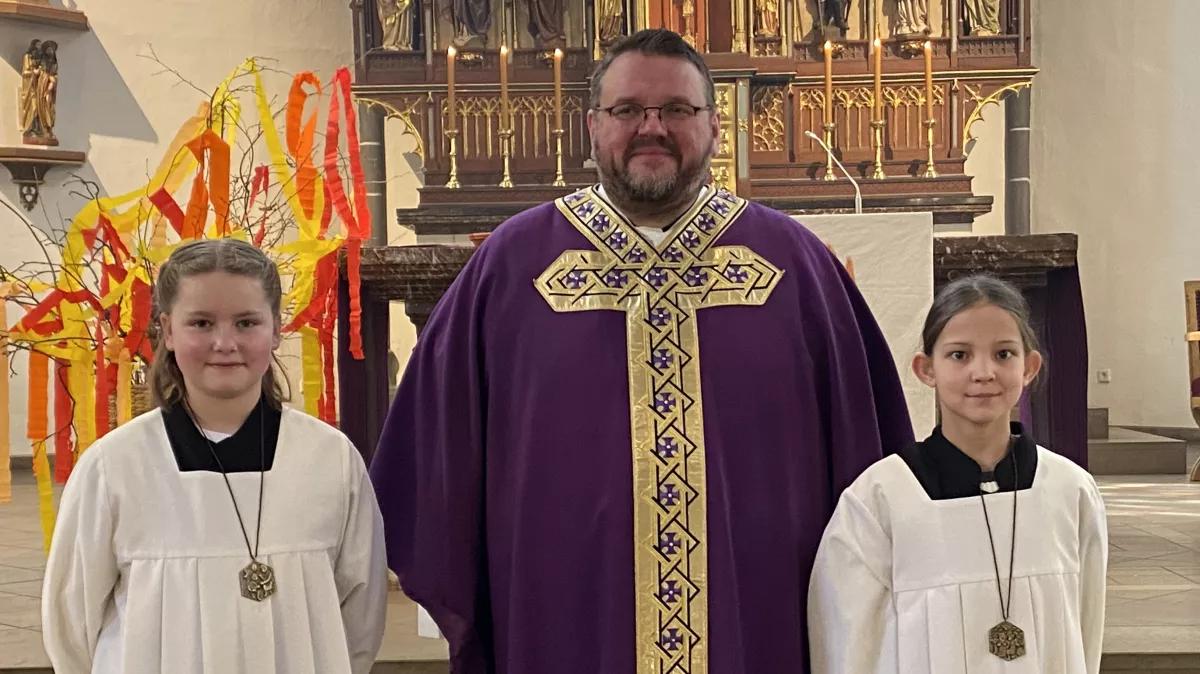 Pastor Markus Leber (Mitte) freut sich über die beiden neuen Messdienerinnen in der St.-Agatha-Gemeinde Altenhundem, Lya Schulte (l.) und Helena Gödde.