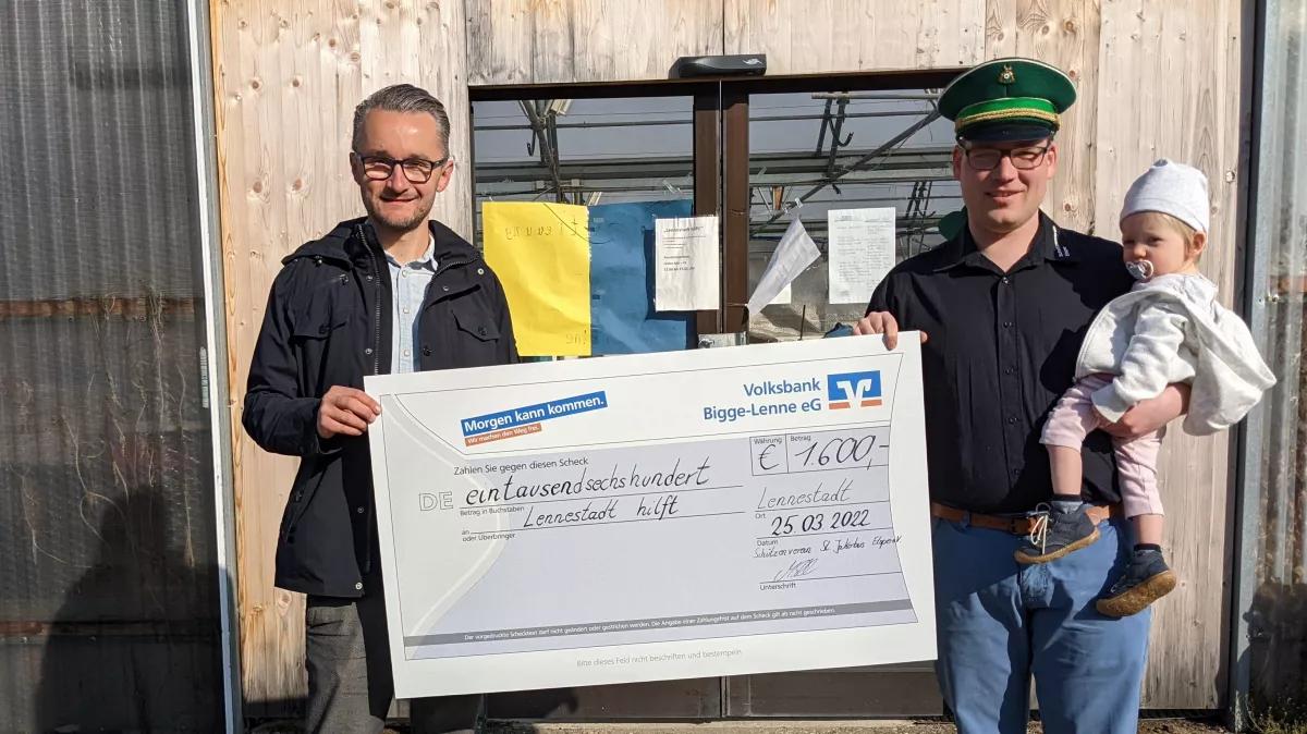 Maximilian Ellinger übergibt den symbolischen Scheck an Matthias Wanzek (l.).