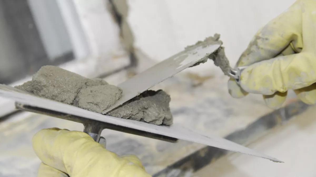 Kelle in Maurerhand: Der Bau sucht händeringend Leute. Trotzdem warten Bauarbeiter dringend auf ein Signal der Arbeitgeber, den Branchenmindestlohn als untersten Lohnsockel nicht aufs Spiel zu setzen.